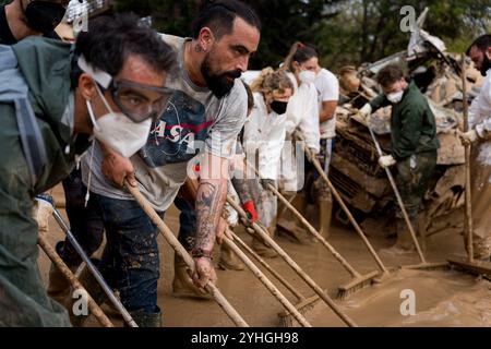 Catarroja, Espagne. 9 novembre 2024. On voit des volontaires nettoyer manuellement la rue de la boue avec des râteaux. Plus de 200 personnes ont été tuées dans les crues soudaines qui ont touché la région autour de Valence, en particulier les villes de Paiporta, SedavÃ¬ et Benatusser, dans ce qui est considéré comme la pire catastrophe naturelle de l'histoire de l'Espagne et l'une des pires de l'histoire de l'Europe. Les inondations ont été causées par un phénomène atmosphérique connu sous le nom de Dana. Des controverses ont surgi autour de la lenteur de la réponse des services d'urgence et du gouvernement. (Crédit image : © Davide Bonaldo/SOPA images via ZUMA Press Wire) EDITORI Banque D'Images