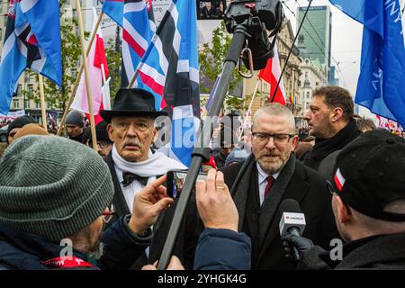 Varsovie, Pologne. 11 novembre 2024. Grzegorz Braun (à droite), membre controversé d'extrême droite au Parlement européen, est interviewé aux côtés de Janusz Korwin-Mikke, politicien d'extrême droite et ancien membre du Parlement européen. Des citoyens polonais de tout le pays défilent dans les rues de Varsovie pour célébrer le jour de l'indépendance. L’événement rassemble des dizaines de milliers de participants, et les Polonais patriotiques se rassemblent pour célébrer. Beaucoup de familles amènent leurs enfants. La marche a des nuances religieuses avec beaucoup de symbolisme religieux vu dans les drapeaux et les bannières. Crédit : SOPA images Limited/Alamy Li Banque D'Images