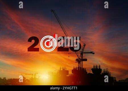 La construction de grues se prépare à accueillir la nouvelle année 2025 au coucher du soleil. Silhouette du nouvel an. 2024 changé à 2025. Chantier de construction de silhouette. Banque D'Images