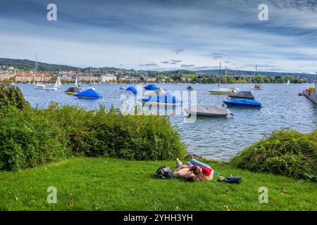 Zurich, Suisse - un couple de jeunes hommes et femmes se détendent sur les rives du lac de Zurich (Zurichsee). Banque D'Images