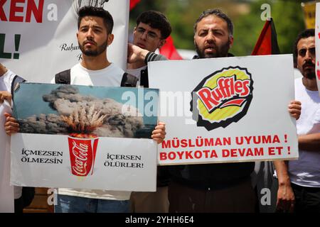 Gaziantep, Turkiye. 09 mai 2024. Des étudiants de Gaziantep tiennent des banderoles d’entreprises occidentales soutenant Israël lors d’une manifestation sur le campus en solidarité avec les Palestiniens de Gaza. Les participants ont agité le drapeau palestinien, hissé des banderoles condamnant l'offensive militaire israélienne en cours dans l'enclave côtière, tout en manifestant leur soutien aux manifestants pro-palestiniens sur les campus universitaires des États-Unis. Des modèles de bébés enveloppés ont été posés sur le sol avec des fleurs pour pleurer le grand nombre d'enfants tués à Gaza Banque D'Images