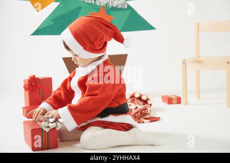 Boîte cadeau et fille habillée en Père Noël Banque D'Images