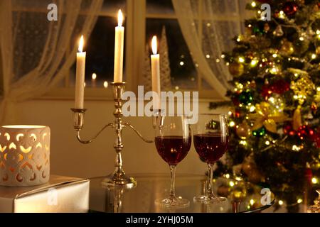 Chambre avec sapin de Noël, verres à vin et bougies Banque D'Images