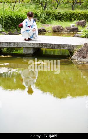 Femme en yukata dans le jardin japonais Banque D'Images