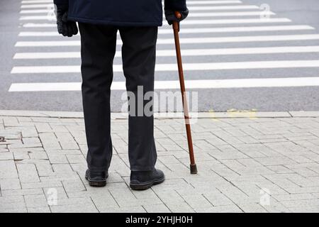 Homme avec une canne sur la rue de la ville. Concept de vieillesse, maladies de la colonne vertébrale ou maladie articulaire Banque D'Images