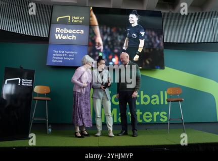 L'ancienne arbitre de football Rebecca Welch pose avec son prix et ses parents lors de sa cérémonie d'intronisation au Hall of Fame au National Football Museum de Londres. Date de la photo : mardi 12 novembre 2024. Banque D'Images