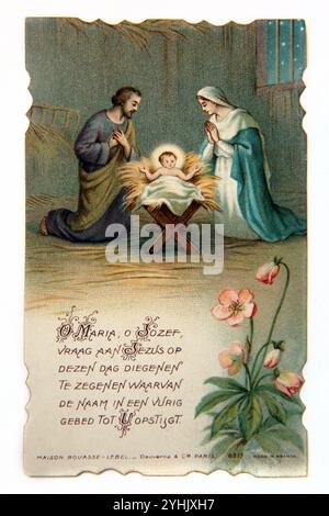 Carte de prière catholique néerlandaise vintage avec illustration de l'enfant Jésus-Christ dans un mangeoire avec la Vierge Marie et Saint Joseph priant à ses côtés Banque D'Images