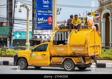 Camion à ordures jaune. Camion à ordures recyclables et hommes en uniforme collectant les ordures dans la vieille ville de Phuket en Thaïlande. Photo de rue, éditorial-juillet 27,2024 Banque D'Images