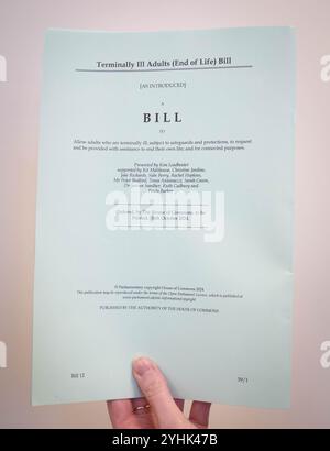 Une personne détient une copie papier du projet de loi sur les adultes malades en phase terminale (fin de vie) proposé par le député travailliste Kim Leadbeater qui sera débattu et probablement voté le 29 novembre, le premier vote des communes sur l'aide à mourir depuis 2015. Date de la photo : lundi 11 novembre 2024. Banque D'Images