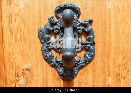 Espagne, Valence, 29 mars 2024 : Antique Door Knocker avec des sculptures animales complexes sur une entrée en bois en plein soleil Banque D'Images