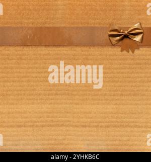 Emballage en papier recouvert de ruban adhésif avec noeud décoratif. Ruban de masquage avec papier. Bandes de ruban adhésif grunge vintage et arc sur vieux texte en carton Banque D'Images