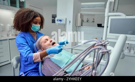 Dentist demonstrates correct brushing techniques, showing patient practical steps to maintain healthy teeth between visits. Stock Photo