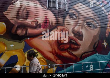 Un homme passe devant une peinture murale à Chinatown, Bangkok. Banque D'Images