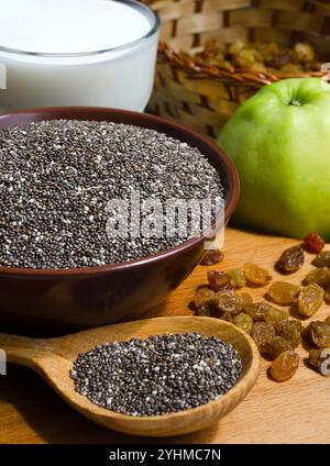 Chia dans un bol, raisins secs et yaourt. Le chia est une plante de la famille des Lamiaceae, une espèce du genre sauge. Banque D'Images