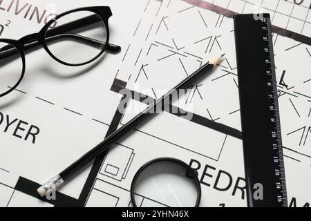 Règle, lunettes, loupe et crayon sur différents dessins architecturaux, vue de dessus Banque D'Images