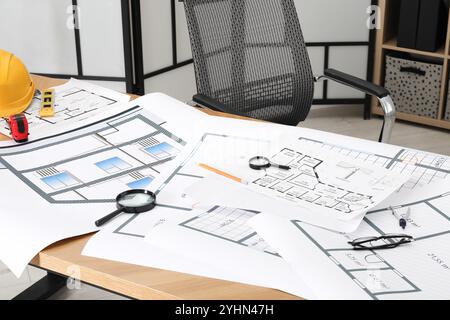 Différents dessins d'ingénierie et outils sur table en bois dans le bureau de l'architecte Banque D'Images