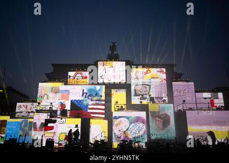 Chute du mur de Berlin - commémoration DEU, Deutschland, Allemagne, Berlin, 09.11.2024 Projektion von Schilder und Plakaten mit Symbolen zur Wiedervereinigung Fall der Berliner Mauer und Freiheit sowie Beleuchtung als Kunstaktion zur Erinnerung an den 35. Jahrestag des Mauerfalls AM 9. Novembre 1989 unter dem motto Fest der Freiheit am Brandenburger Tor à Berlin Deutschland . Die Mauer, die 1961 von der ehemaligen ostdeutschen Regierung errichtet wurde, fiel wahrend einer friedlichen Revolution AM 9. Novembre 1989 und ebnete den Weg für die Wiedervereinigung der beiden deutschen Staaten. Die M Banque D'Images