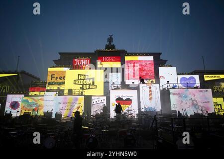 Chute du mur de Berlin - commémoration DEU, Deutschland, Allemagne, Berlin, 09.11.2024 Projektion von Schilder und Plakaten mit Symbolen zur Wiedervereinigung Fall der Berliner Mauer und Freiheit sowie Beleuchtung als Kunstaktion zur Erinnerung an den 35. Jahrestag des Mauerfalls AM 9. Novembre 1989 unter dem motto Fest der Freiheit am Brandenburger Tor à Berlin Deutschland . Die Mauer, die 1961 von der ehemaligen ostdeutschen Regierung errichtet wurde, fiel wahrend einer friedlichen Revolution AM 9. Novembre 1989 und ebnete den Weg für die Wiedervereinigung der beiden deutschen Staaten. Die M Banque D'Images