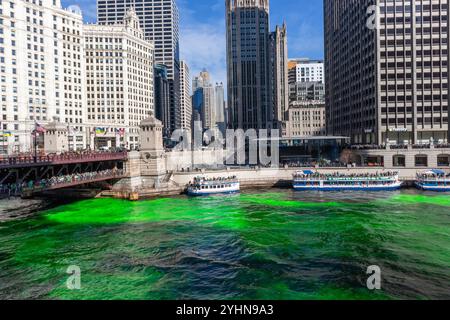 Spectateurs debout sur le pont du sable sur la rivière Chicago qui a été teint en vert pour la fête de Patrick Banque D'Images