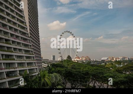 Une vue sur Singapour avec une partie des balcons de l'hôtel Marina Bay Sands au premier plan donnant sur l'attraction Singapore Flyer. Banque D'Images