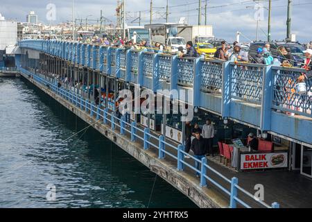 25/10/2024. Istanbul, Turquie. Pêcheurs sur le pont de Galata, qui a été construit par la société de construction turque STFA à quelques mètres du pont précédent, entre Karaköy et Eminönü, et achevé en décembre 1994. Il s'agit d'un pont basculant de 490 m (1 610 ft) de long avec une portée principale de 80 m (260 ft). Le pont du pont est large de 42 m (138 pi) et comporte deux voies de circulation et une passerelle dans chaque direction. Les voies de tramway qui descendent au milieu permettent au tramway T1 de circuler de Bağcılar, dans la banlieue ouest, à Kabataş. En 2003, une série de restaurants ont été ajoutés aux unders Banque D'Images