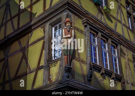 Sculpture en bois sculpté d'un homme sur un poteau d'angle sur une maison médiévale traditionnelle à colombages dans le quartier de la petite Venise à Colmar, Alsace France Banque D'Images