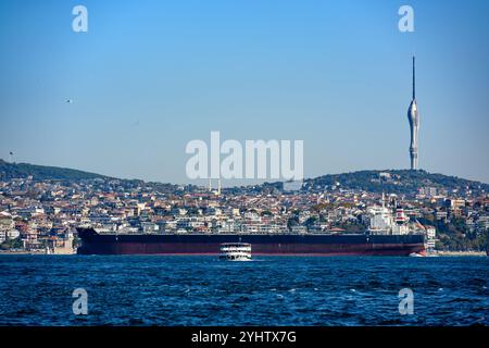 27/10/2024. Istanbul, Turquie. Un grand cargo remontant le Bosphotus en direction de la mer Noire pour le chargement de fret, avec un ferry de passagers se dirigeant vers Eminonou, et la Tour Çamlıca sur le côté asiatique d'Istanbul en arrière-plan. Photo : © Simon Grosset Banque D'Images