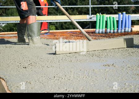 Ouvriers remplissant le sol du deuxième étage avec le béton, le noyau et le bâtiment de construction de coquille Banque D'Images