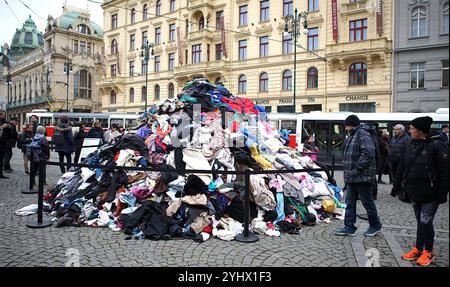 Prague, République tchèque. 12 novembre 2024. Les gens se rassemblent autour d'une pile de vêtements créés pour sensibiliser à la question des déchets textiles à Prague, en République tchèque, le 12 novembre 2024. Crédit : Dana Kesnerova/Xinhua/Alamy Live News Banque D'Images