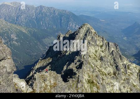 Randonneurs appréciant la vue panoramique depuis le sommet rocheux du Mont Rysy (2501m), le plus haut sommet de Slovaquie et les sommets des Tatras Banque D'Images