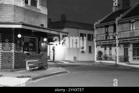 La banlieue de Sydney de The Rocks, établie lors de la colonisation en 1788, contient de nombreux sites classés au patrimoine et est la plus ancienne banlieue d'Australie. Ses bâtiments, escaliers et arcades ont été construits avec du grès local, d'où le nom de la région. Jusqu'aux années 1870, c'était un bidonville où les « gangs de rasoirs » flânaient la nuit dans les ruelles. C'est maintenant un quartier touristique chargé d'histoire entouré de Dawes point, Millers point et Barangaroo, souvent considéré comme faisant partie du quartier des Rocks. Sur la photo : une vue nocturne de l'hôtel Palisade à Millers point sur Bettington Street à Dalgety Road, regardant vers Rodens Lane. Banque D'Images