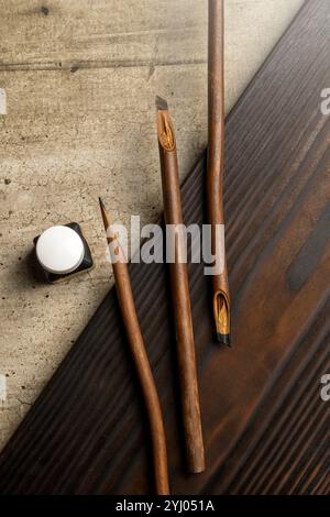 Ensemble de roseaux de calligraphie recouvert d'encre avec encrier sur la table. Encre pour stylo à roseaux pour écrire la calligraphie arabe Banque D'Images