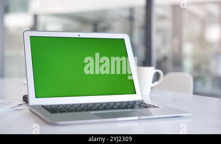 Écran vert, bureau et ordinateur portable pour espace maquette, promo publicitaire ou espace réservé au bureau. Affichage, ordinateur ou moniteur avec chroma key pour la conception Banque D'Images