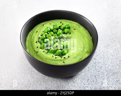 Soupe à la crème de pois verts avec des craquelins sur une table grise. Vue de dessus. Banque D'Images