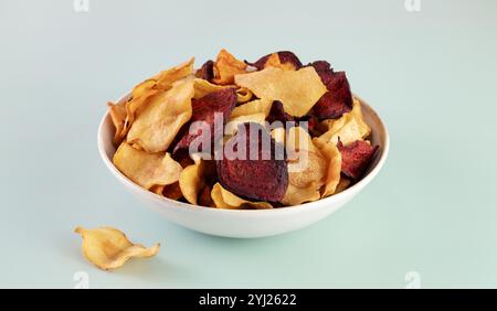 Un bol de chips bio végétales à base de betteraves, de carottes et de racine de céleri sur fond gris. Vue de dessus. Banque D'Images
