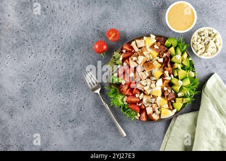 Salade de Cobb américain avec tomates, bacon, poulet, œufs, avocat, fromage bleu sur fond bleu. Vue de dessus. Copier l'espace. Banque D'Images