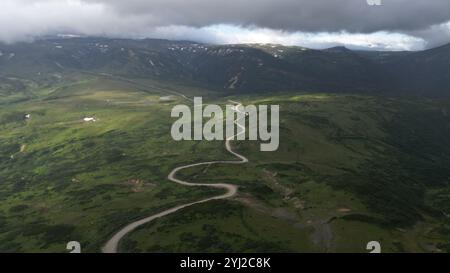 Vue aérienne d'une belle rivière sinueuse entourée de vertes luxuriantes collines et de la nature Banque D'Images