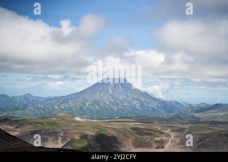 Volcan Vilyuchinsky, région du Kamtchatka. Un volcan majestueux entouré d'une végétation luxuriante, d'une nature vibrante et d'un ciel bleu clair au-dessus Banque D'Images