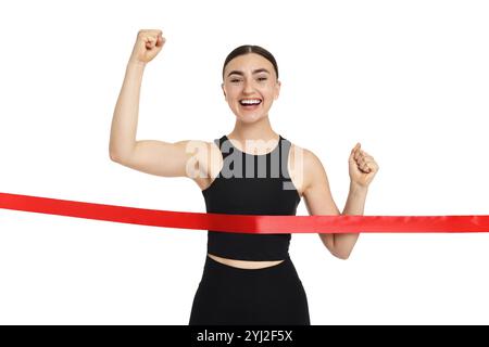 Belle femme en sportswear traversant la ligne d'arrivée rouge sur fond blanc Banque D'Images