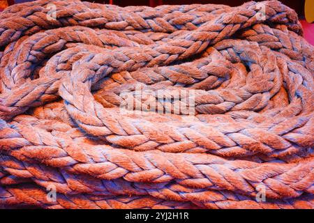 Bobines tordues de corde brune épaisse dans un tas sur un navire porte-conteneurs. Banque D'Images