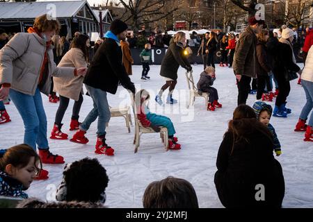 Famille avec enfants profitant de la patinoire en face du musée Rijks dans le cadre de l'animation de Noël sur Museumplein a Amsterdam en Hollande en t Banque D'Images