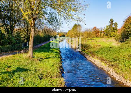 Paysage de la rivière Wurm entre herbe verte et arbres d'automne, pont en arrière-plan, reflet de la lumière du soleil sur la surface de l'eau, vue depuis l'angle supérieur, sunn Banque D'Images