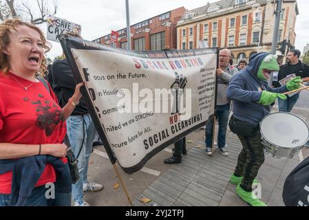 Londres, Royaume-Uni. 23 septembre 2017. La bannière de Focus E15 appelant à « le logement social, PAS le nettoyage social » et une grenouille frappant un tambour lors de la marche dans le nord de Londres d'un rassemblement à Tottenham à Finsbury Park contre le soi-disant véhicule de développement Haringey, en vertu de laquelle Haringey Council effectue un énorme transfert de logements sociaux à la multinationale australienne Lendlease. Cela entraînera la démolition imminente de plus de 1 300 maisons municipales sur le domaine de Northumberland Park, suivie de la perte similaire de logements sociaux dans l’ensemble de l’arrondissement. Avec 2 milliards de livres sterling, HIS est le plus grand cadeau de Counci Banque D'Images