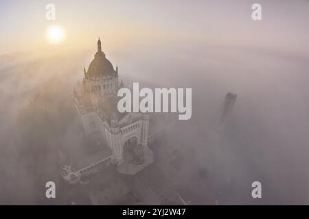 FRANCE. NORMANDIE. CALVADOS (14) LISIEUX. LA FAÇADE OUEST ET LE DÔME DE LA BASILIQUE SAINTE-THÉRÈSE ÉMERGENT DU BROUILLARD MATINAL Banque D'Images