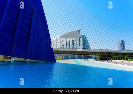 Valence, Espagne - 12 juillet 2024 : vue dynamique de l'architecture moderne à la Cité des Arts et des Sciences avec réflexion sur l'eau bleue. Banque D'Images