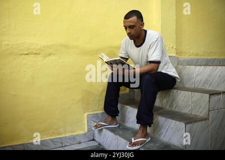 Rio de Janeiro, Brésil. 06 juin 2024. Jorge, un détenu de 29 ans, lit Prisoners de Drauzio Varella, un livre documentaire sur le système pénitentiaire brésilien. Un atelier de lecture a eu lieu au centre de détention Evaristo de Moraes à Rio de Janeiro, au Brésil. Au Brésil, le projet de remise pour lecture vise à réhabiliter les prisonniers en les aidant à réduire leur peine par la lecture de livres. Les autorités espèrent que cela insufflera un amour de la lecture aux détenus et réduira la récidive. Crédit : SOPA images Limited/Alamy Live News Banque D'Images