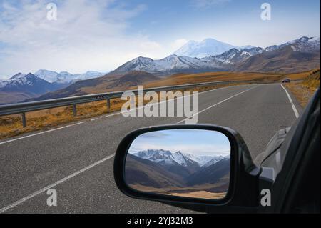 Les montagnes du Caucase sont affichées dans le rétroviseur d'une voiture sur le chemin du mont Elbrus, en Russie Banque D'Images