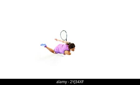 Athlète, joueuse de tennis en position de puissance, raquette bien fixée, ses yeux fixés sur la balle sur fond blanc de studio. Banque D'Images