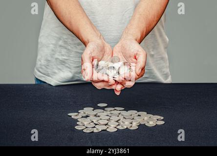 Pièces d'argent dans les mains féminines sur fond flou. Importance de recevoir un soutien financier social Banque D'Images