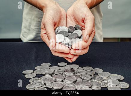 Pièces d'argent dans les mains féminines sur fond flou. Importance de recevoir un soutien financier social Banque D'Images